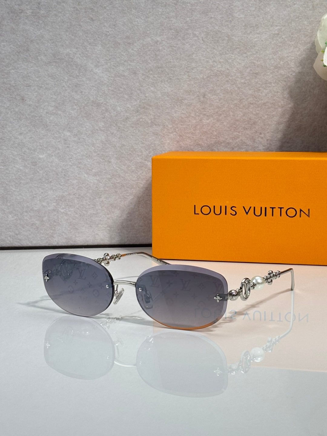Louis Vuitton sunglasses with dark gray-purple lenses and gold metal frame