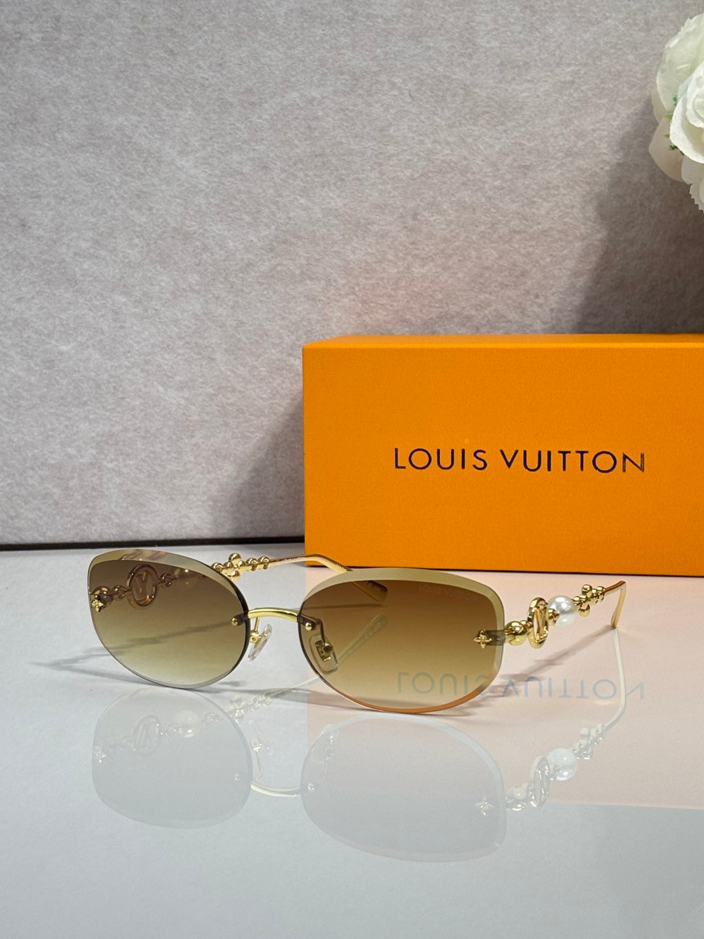 Louis Vuitton sunglasses with tan lenses and gold metal frame, decorative bead detail
