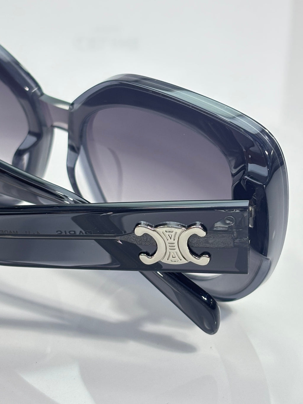 Sunglasses hinge close-up with metal logo plate