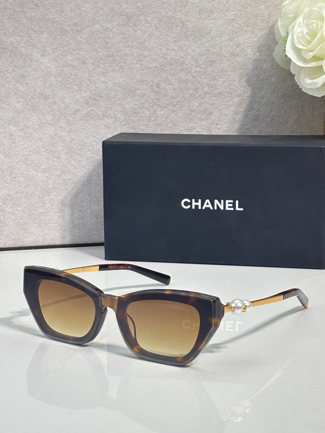 Chanel cat-eye sunglasses with dark acetate frames and amber-tinted lenses