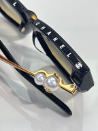 Chanel cat-eye sunglasses detail: gold-tone arms with faux pearl embellishment