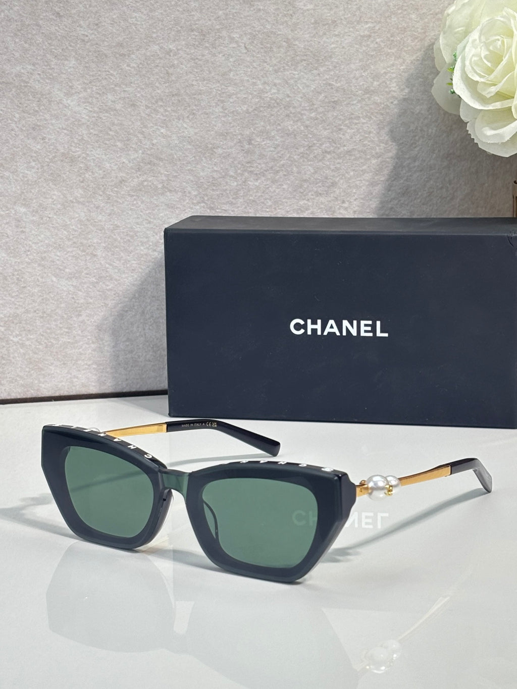 Chanel cat-eye sunglasses with dark acetate frames and green-tinted lenses