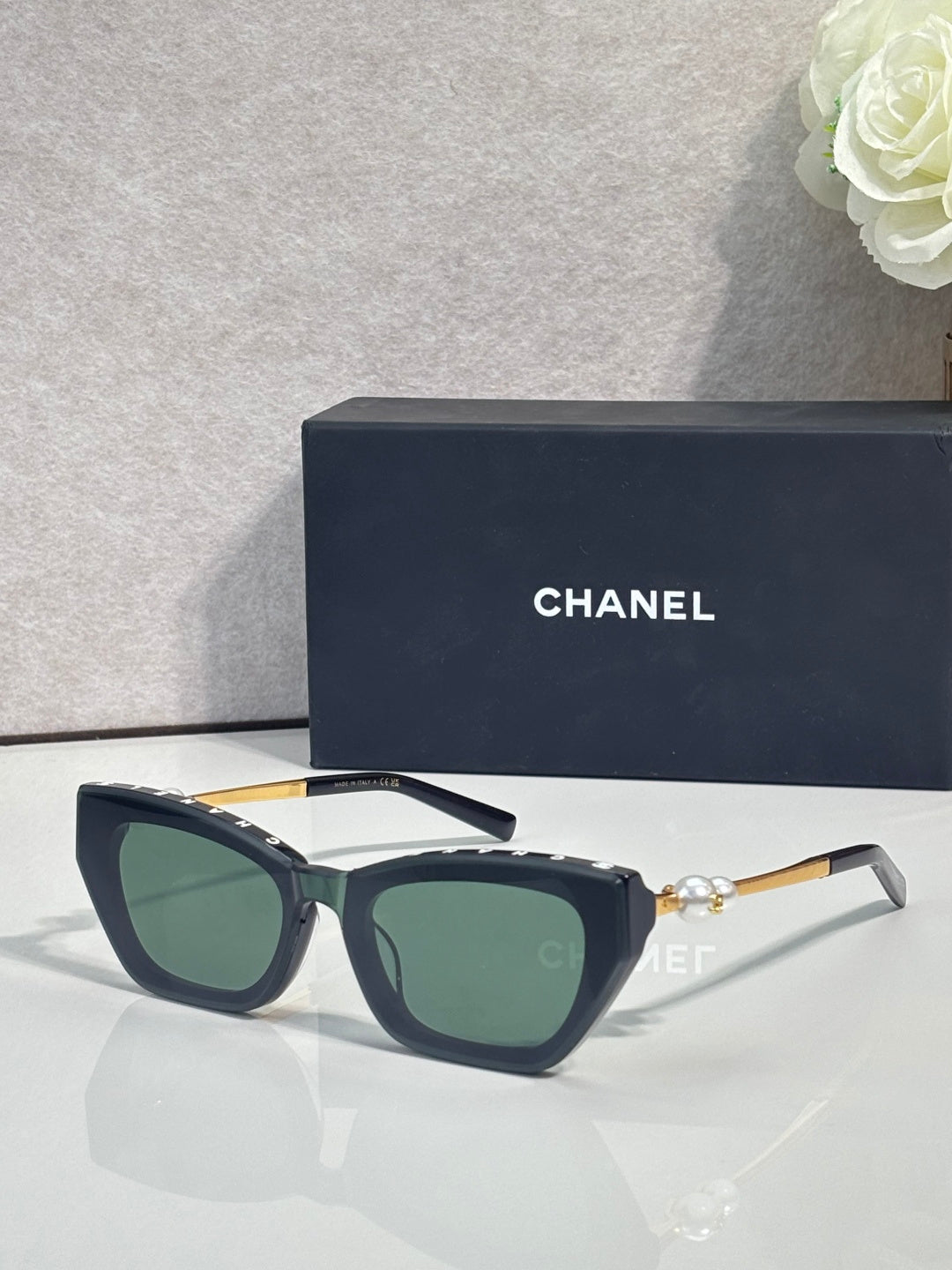 Chanel cat-eye sunglasses with dark acetate frames and green-tinted lenses