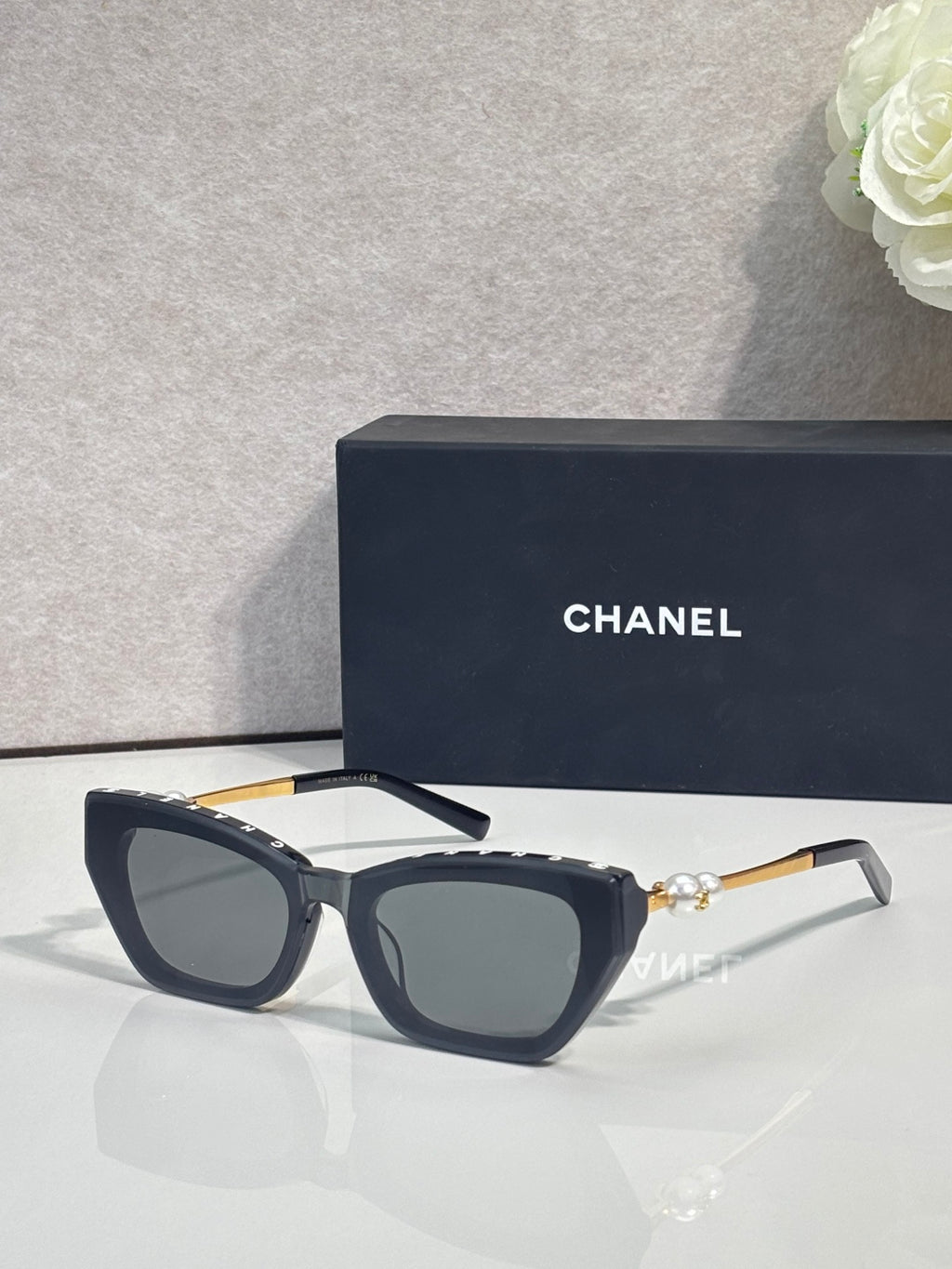 Chanel cat-eye sunglasses with dark acetate frames and blue-gray lenses