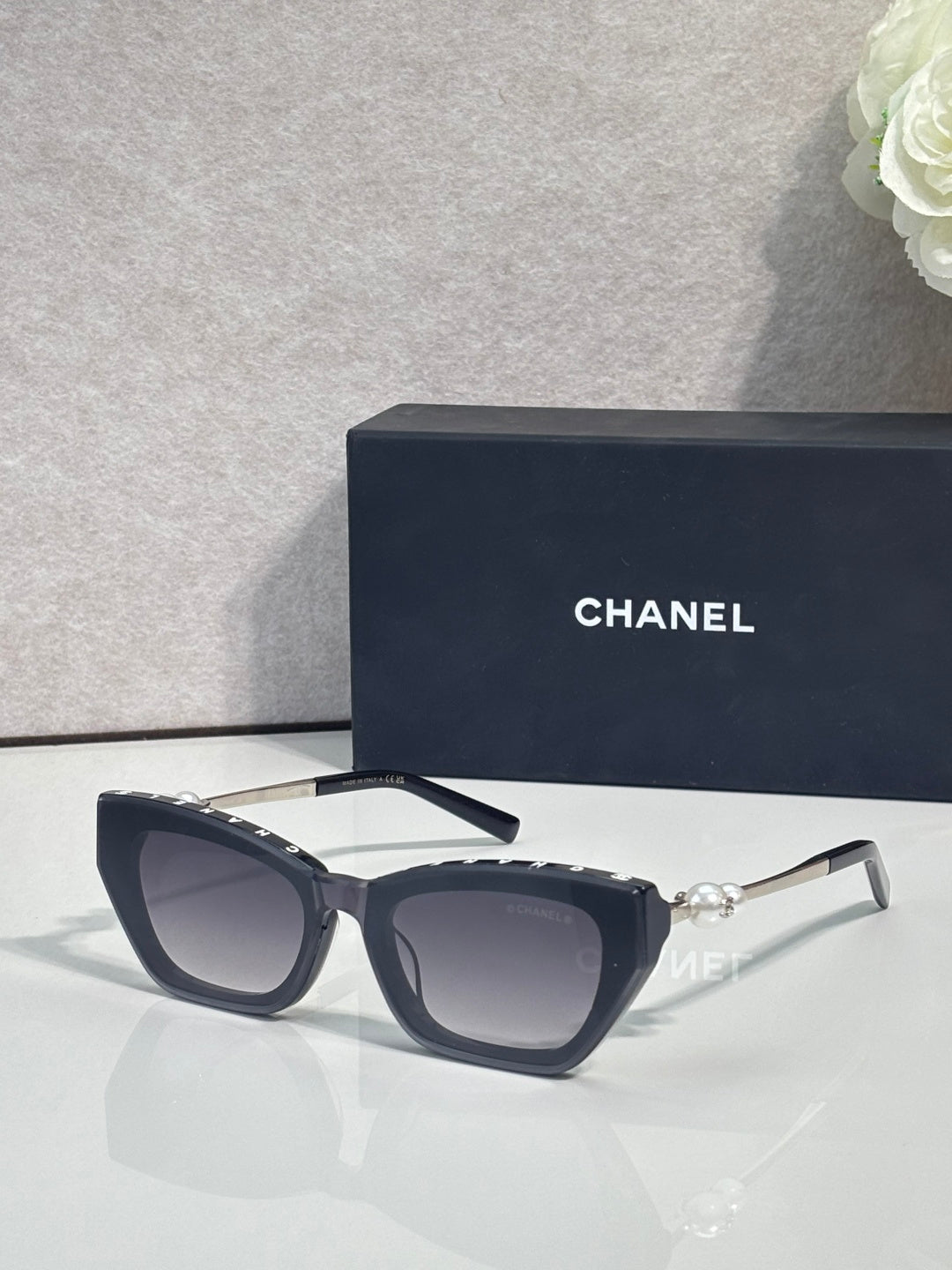 Chanel cat-eye sunglasses with dark acetate frames and light gray lenses