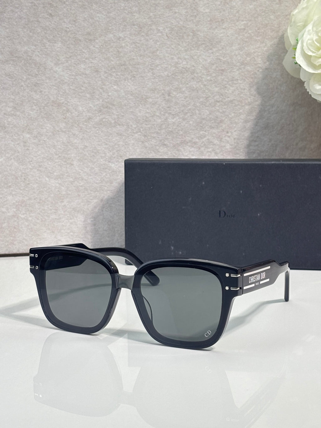 Sunglasses with dark frame, gold-trimmed temples, and gradient lenses