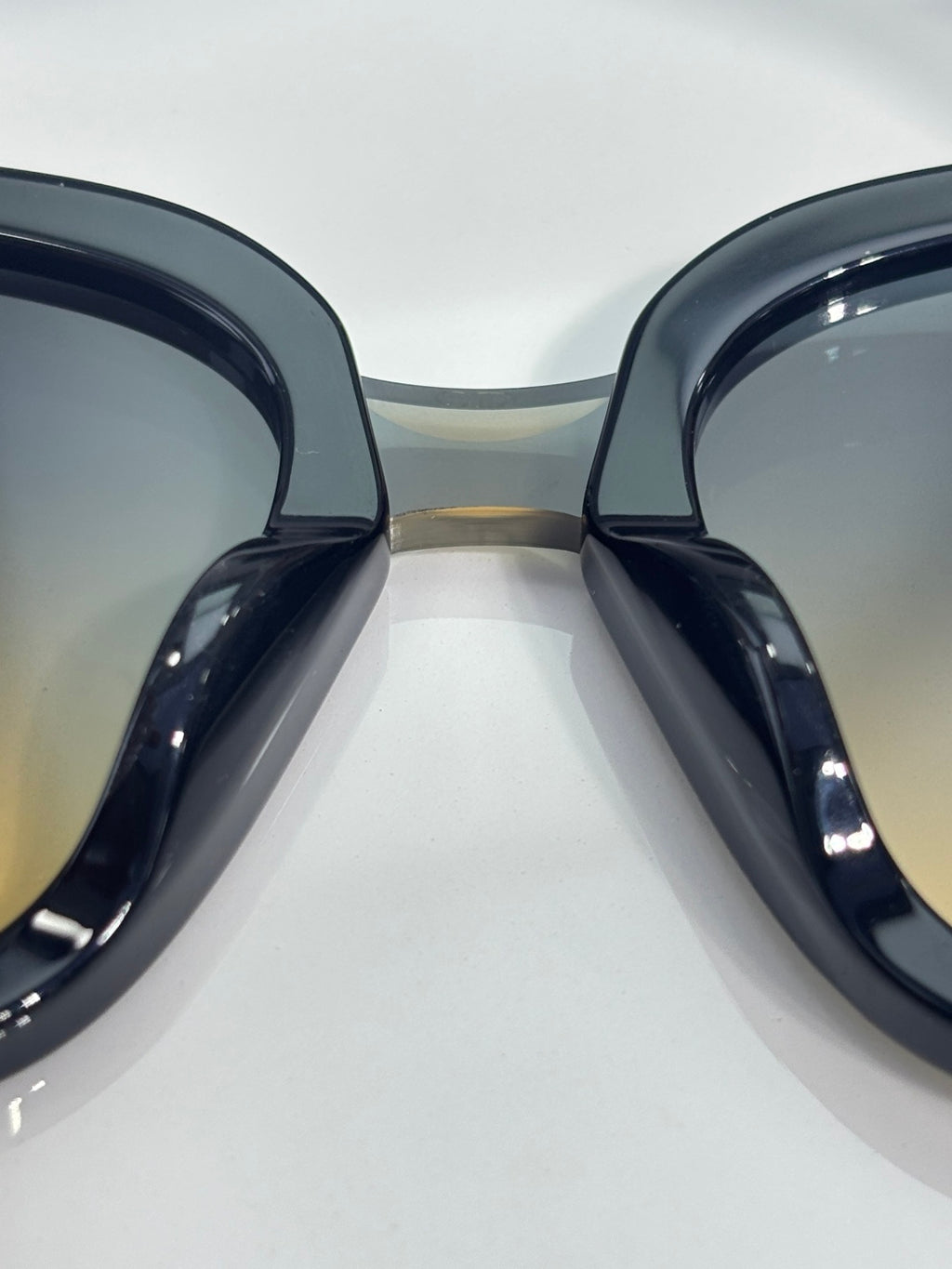 Sunglasses close-up showing two black gradient lenses and thick frame