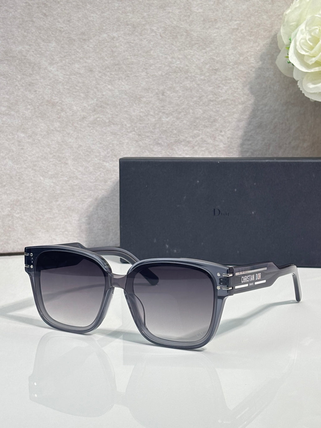 Sunglasses with dark frame and rounded lenses, gold-trimmed temple hinges