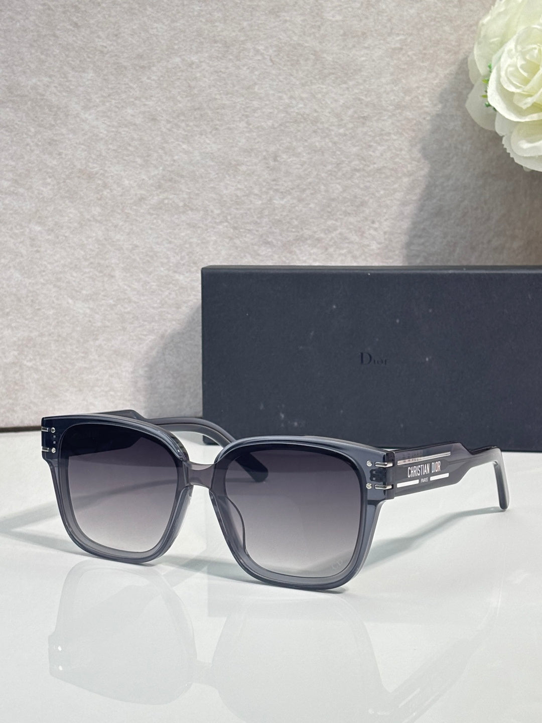 Sunglasses with dark frame and rounded lenses, gold-trimmed temple hinges
