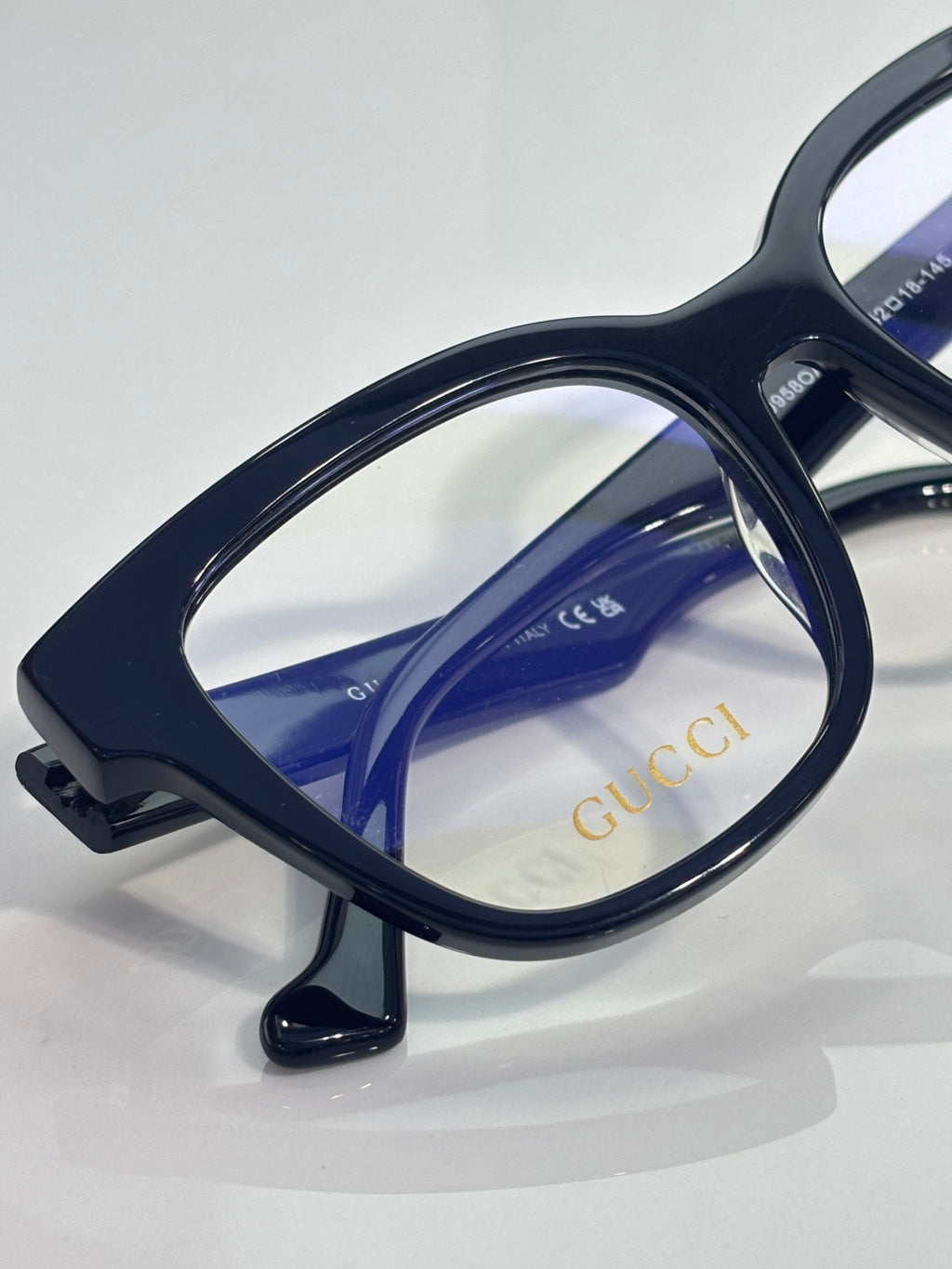 Rectangular eyeglasses with dark navy frame and blue-tinted inner lens, clear lenses