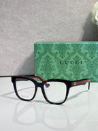 Rectangular eyeglasses with dark navy frame and gold logo details, clear lenses