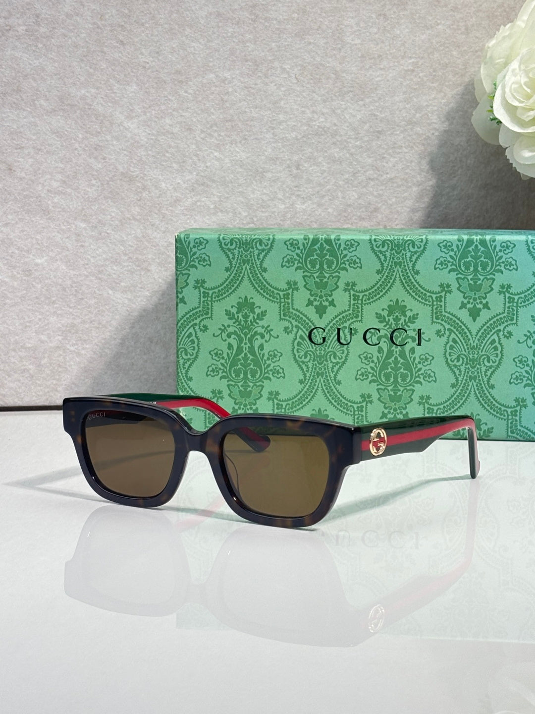 Gucci sunglasses, black square frame, red-green temples, dark tinted lenses