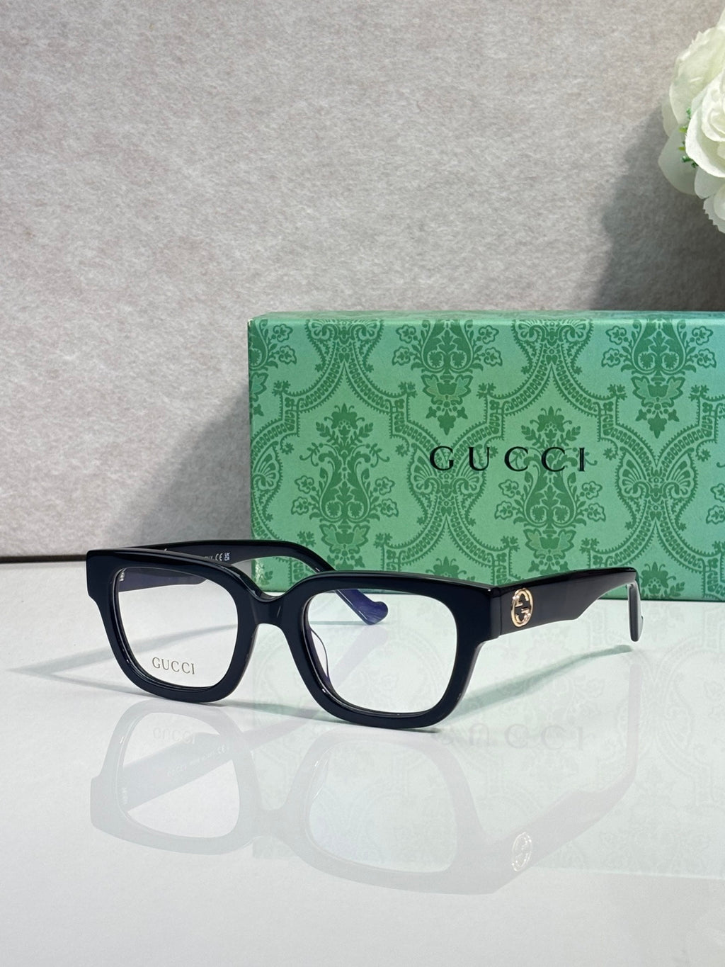 Gucci glasses, black frame with red-green temples, clear blue-tinted lenses