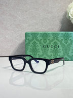 Gucci glasses, black frame with red-green temples, clear blue-tinted lenses
