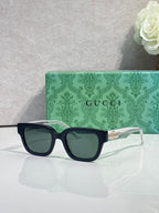 Gucci sunglasses, black frame, red-green temples, dark tinted lenses