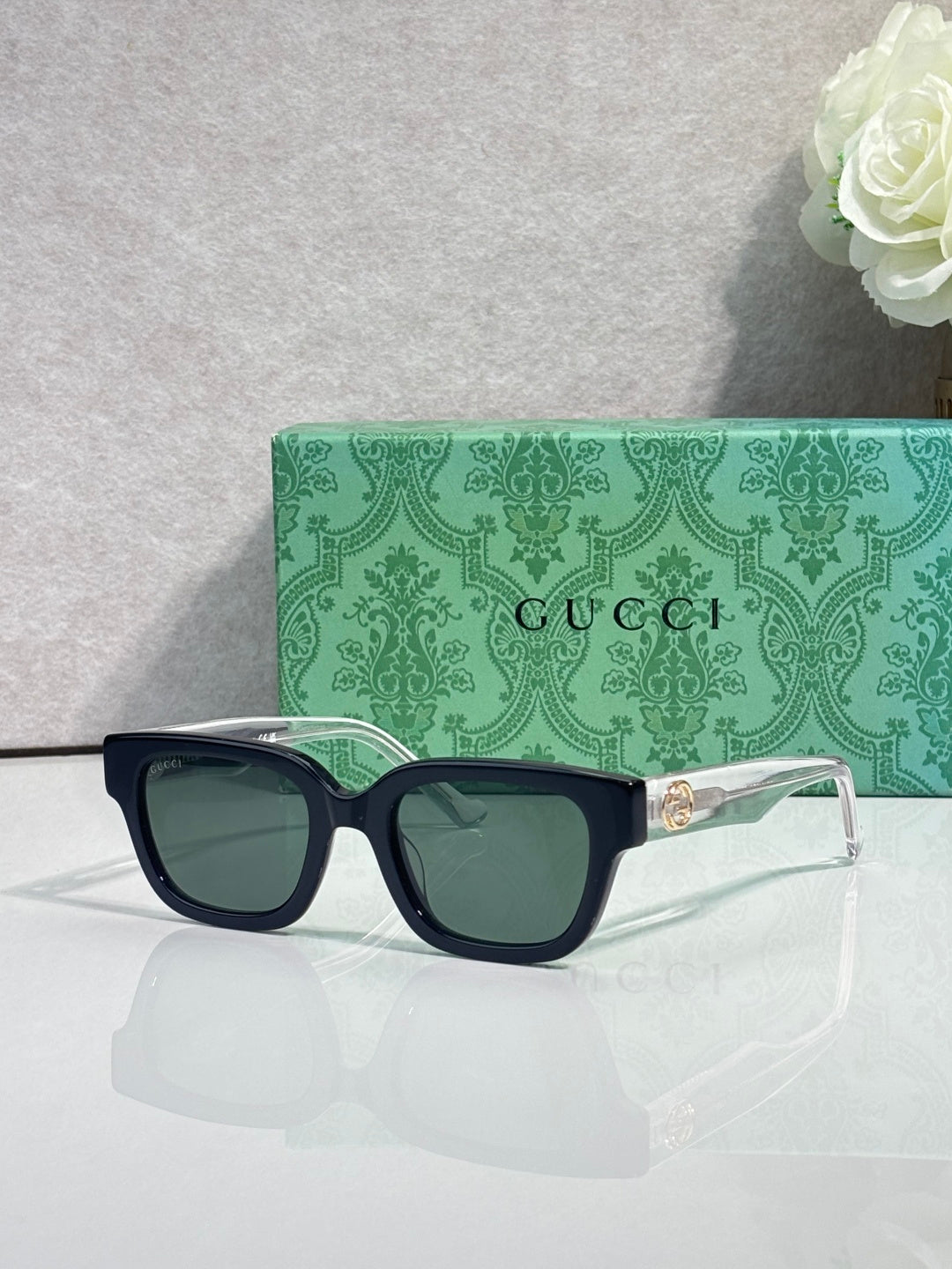 Gucci sunglasses, black frame, red-green temples, dark tinted lenses