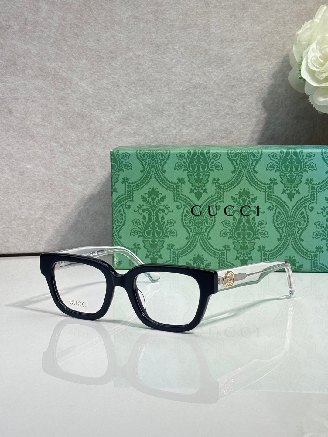 Gucci glasses, black frame with gold-tone side detail, clear lenses