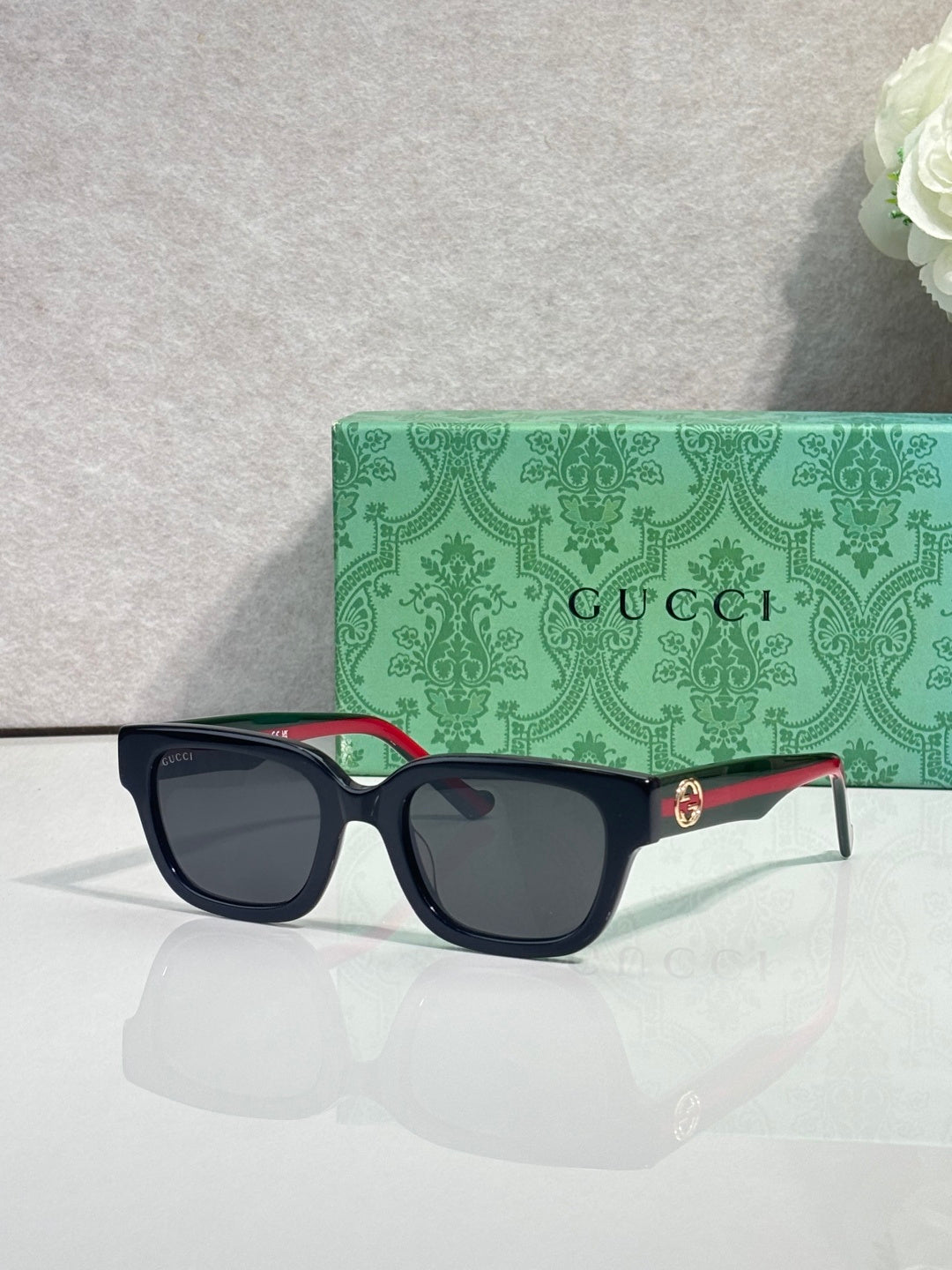 Gucci sunglasses, black square frame, red-green temples, dark lenses
