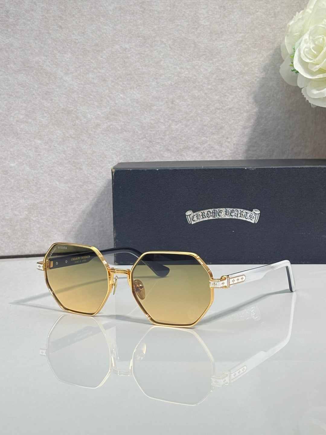 Chrome sunglasses with amber octagonal lenses and gold metal frame with clear side arms