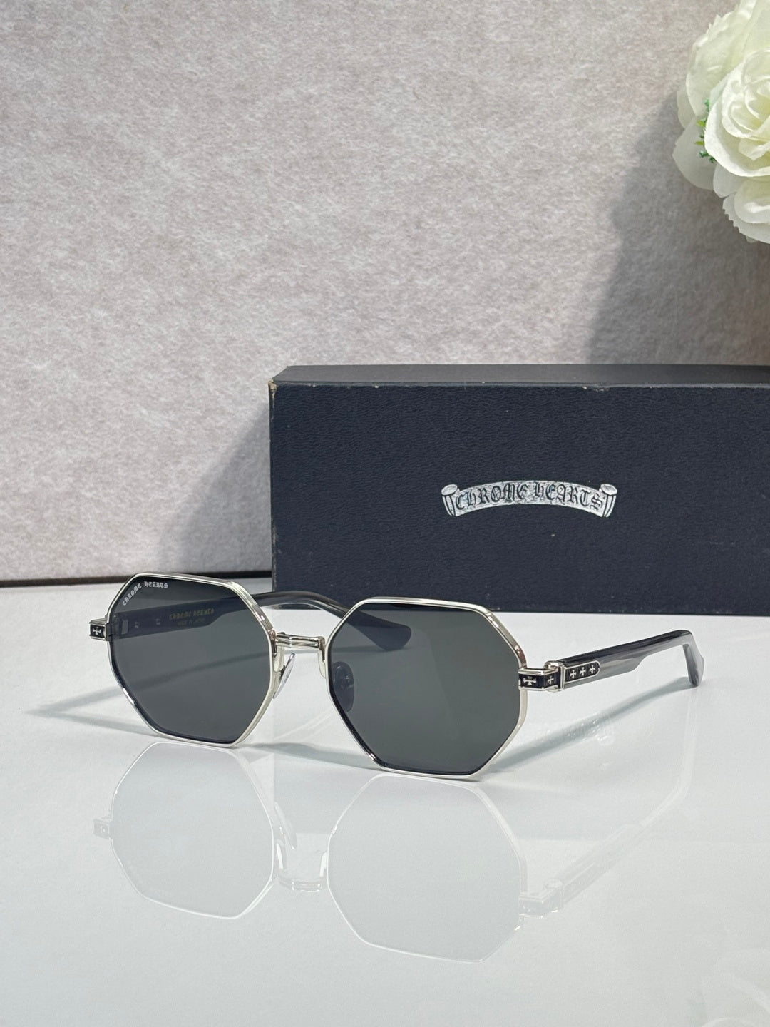 Chrome sunglasses with dark octagonal lenses and silver frame with clear side arms