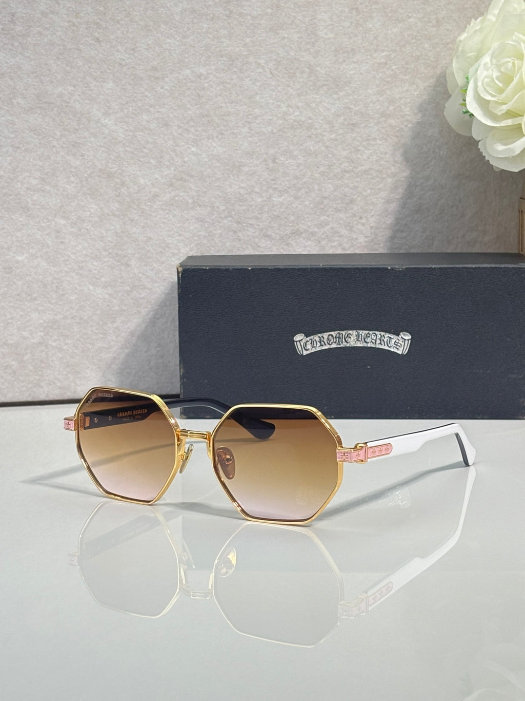Chrome sunglasses with amber octagonal lenses and gold metal frame with white side arms
