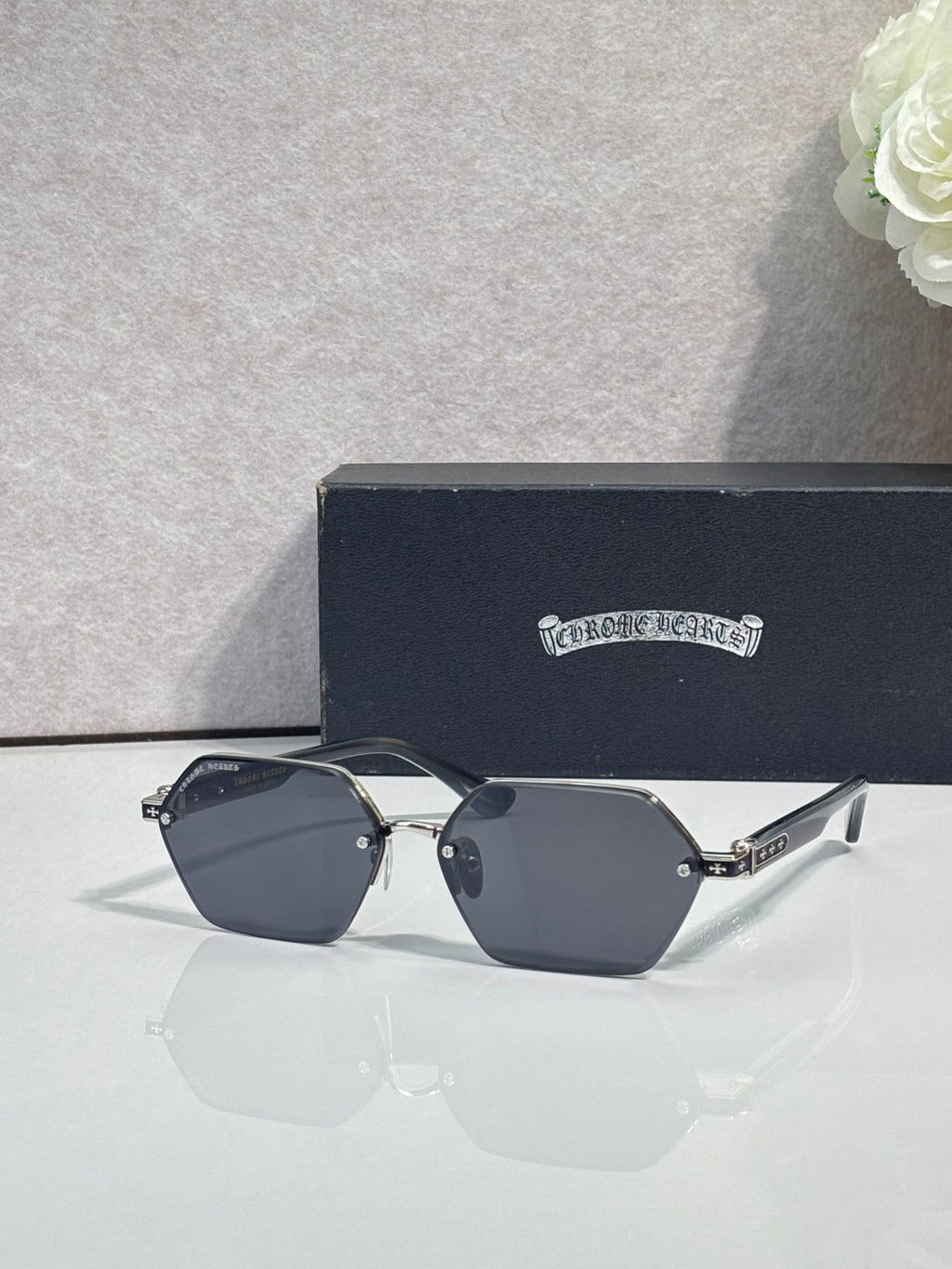 Hexagon sunglasses with dark navy lenses and black frame, gold accents on temples