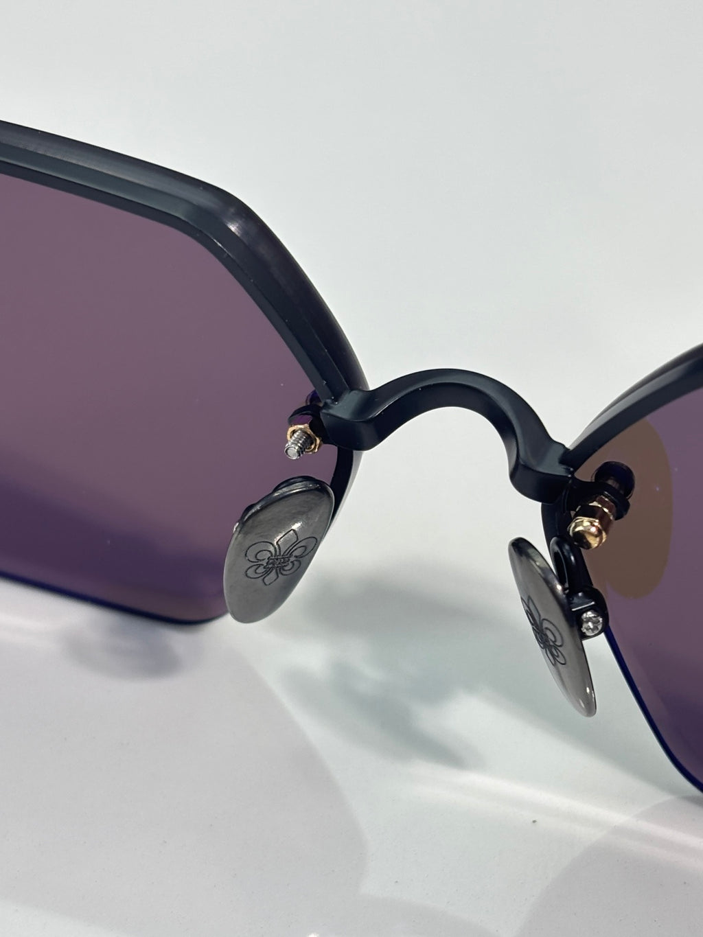 Close-up of hexagon sunglasses frame with purple-tinted lenses and black arms