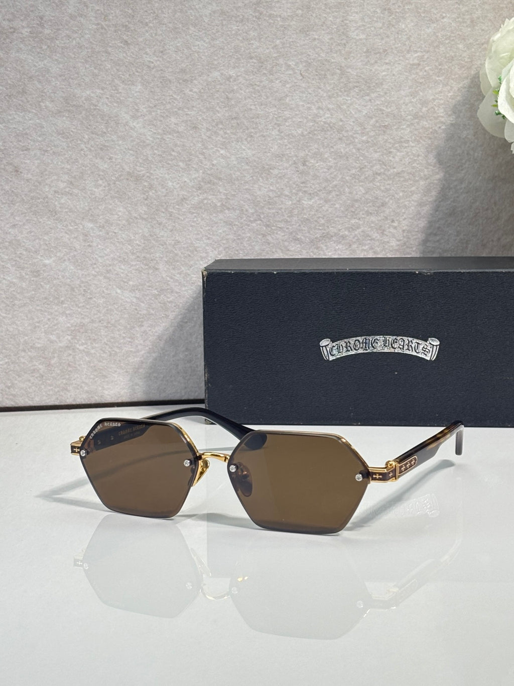 Hexagon sunglasses with brown lenses and gold metal frame, dark temple details