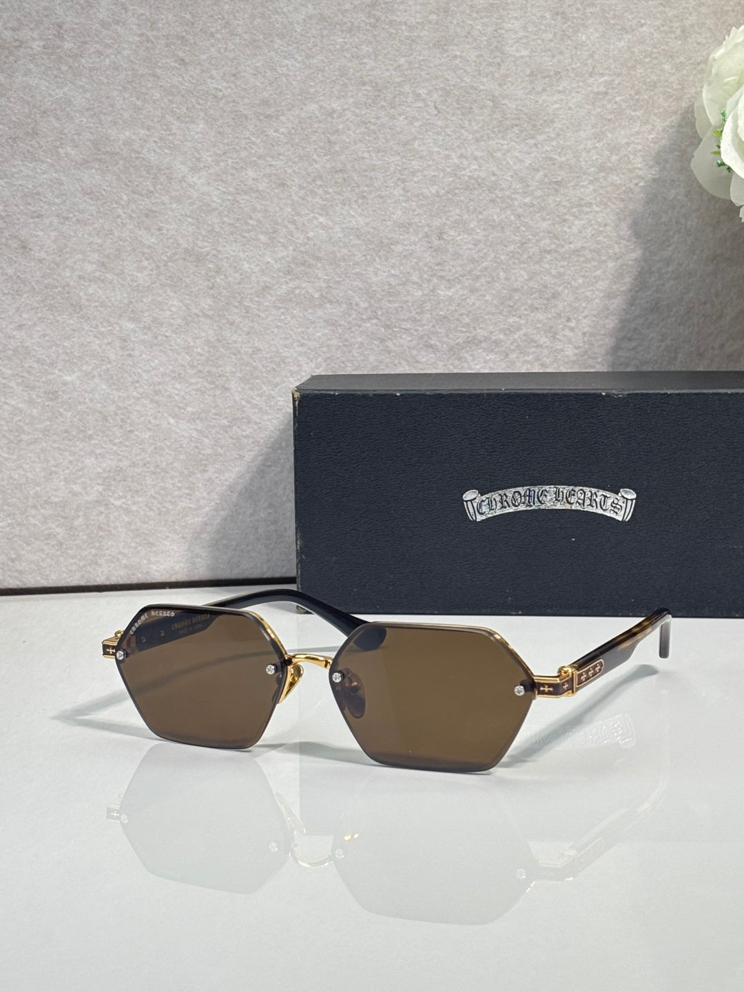 Hexagon sunglasses with brown lenses and gold metal frame, dark temple details