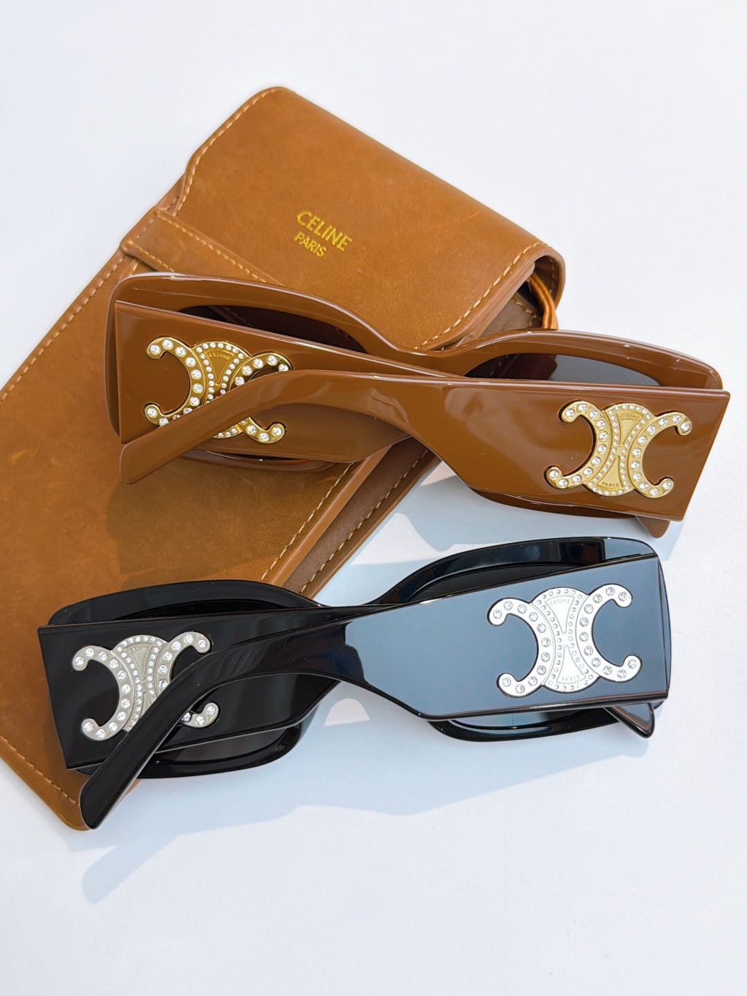 Set of Celine sunglasses with tan, black, and light frames and ornate logos