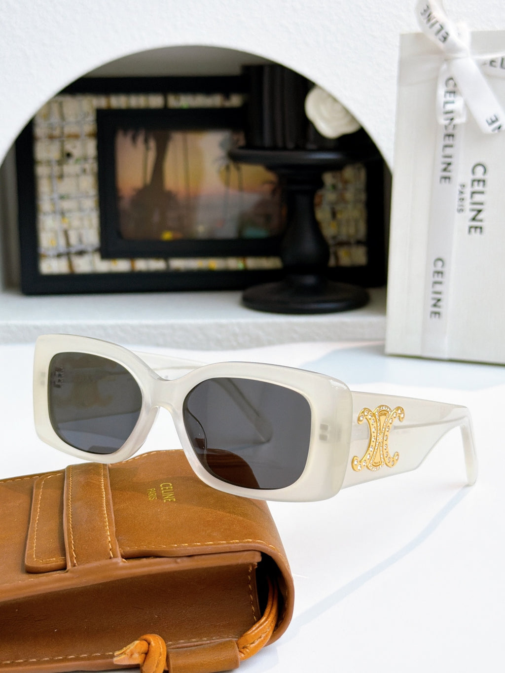 Celine sunglasses with light frames and gold logo on temple, dark lenses