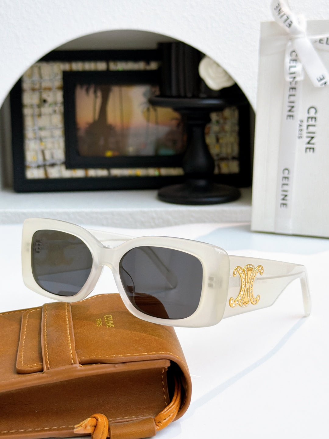Celine sunglasses with light frames and gold logo on temple, dark lenses