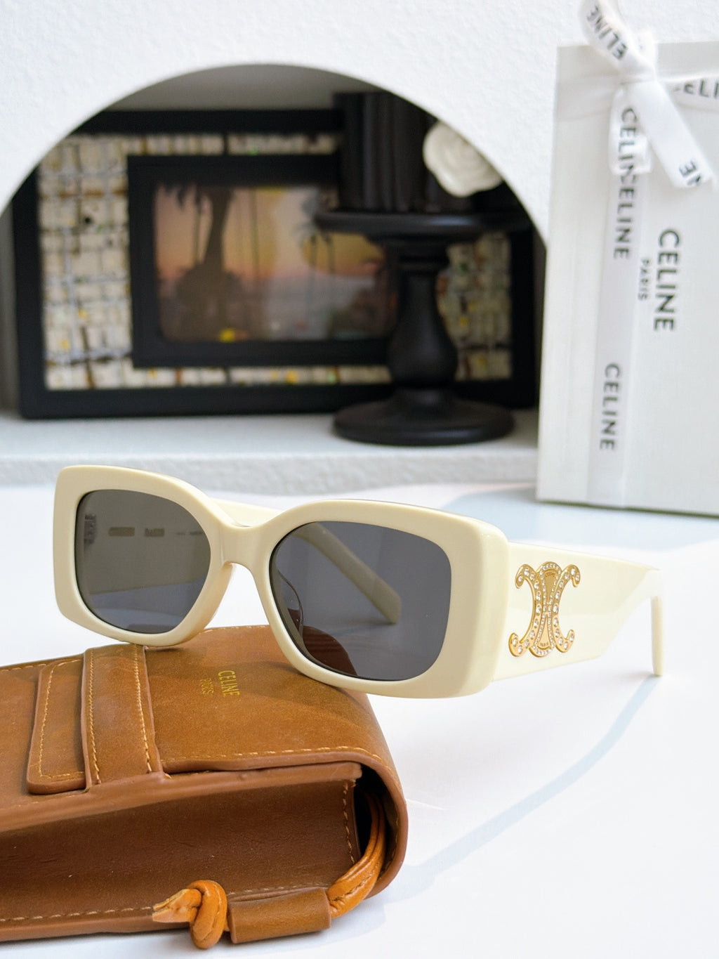 Celine sunglasses with cream frames and gold logo on temple, dark lenses