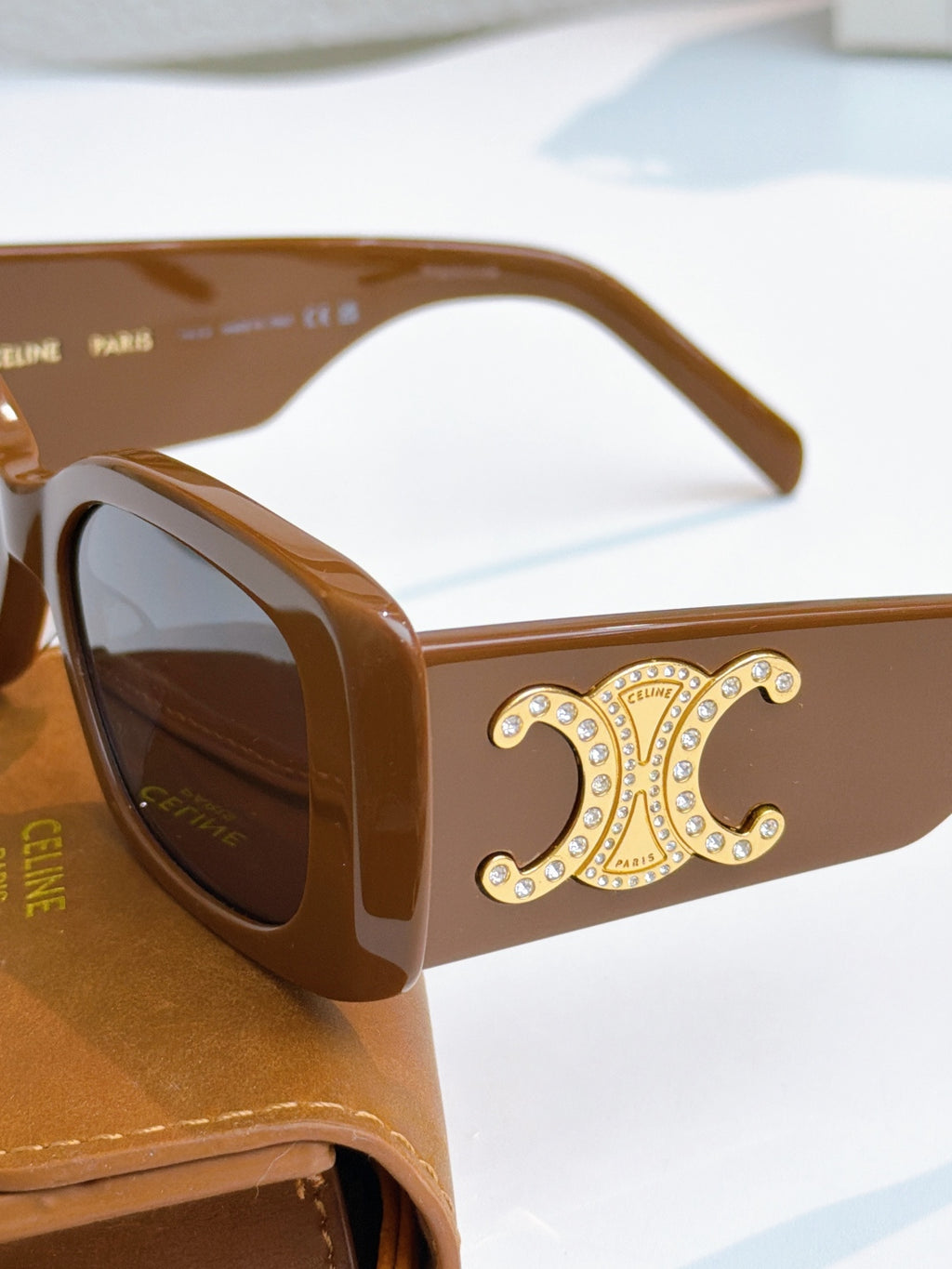 Celine sunglasses close-up with brown frames, gold logo detail, tinted lenses
