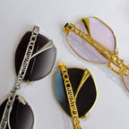 MiuMiu glasses in silver and gold with cat-eye frames, chain details, dark lenses