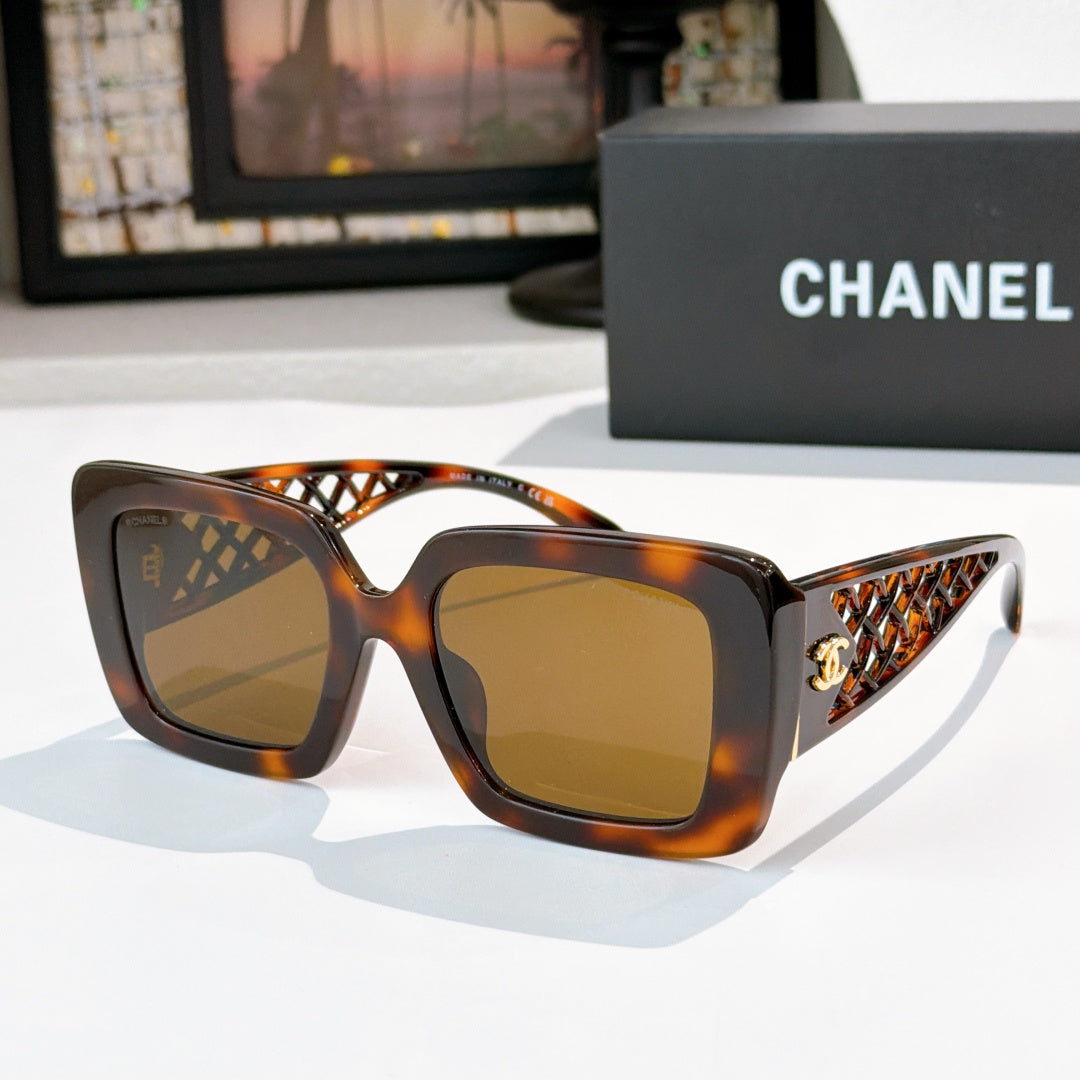 Square sunglasses with tortoiseshell frame and amber-tinted lenses, gold logo on temple