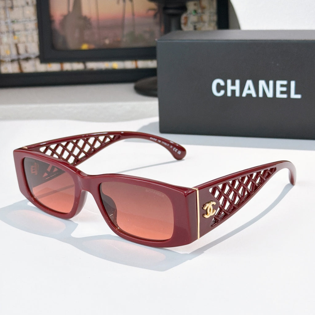 Red sunglasses with diamond-pattern temples and gold Chanel logo