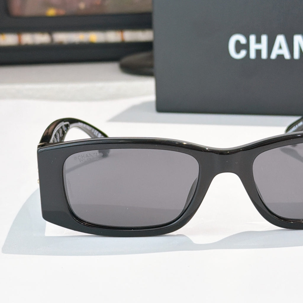 Black sunglasses with wide rectangular lenses and curved arms