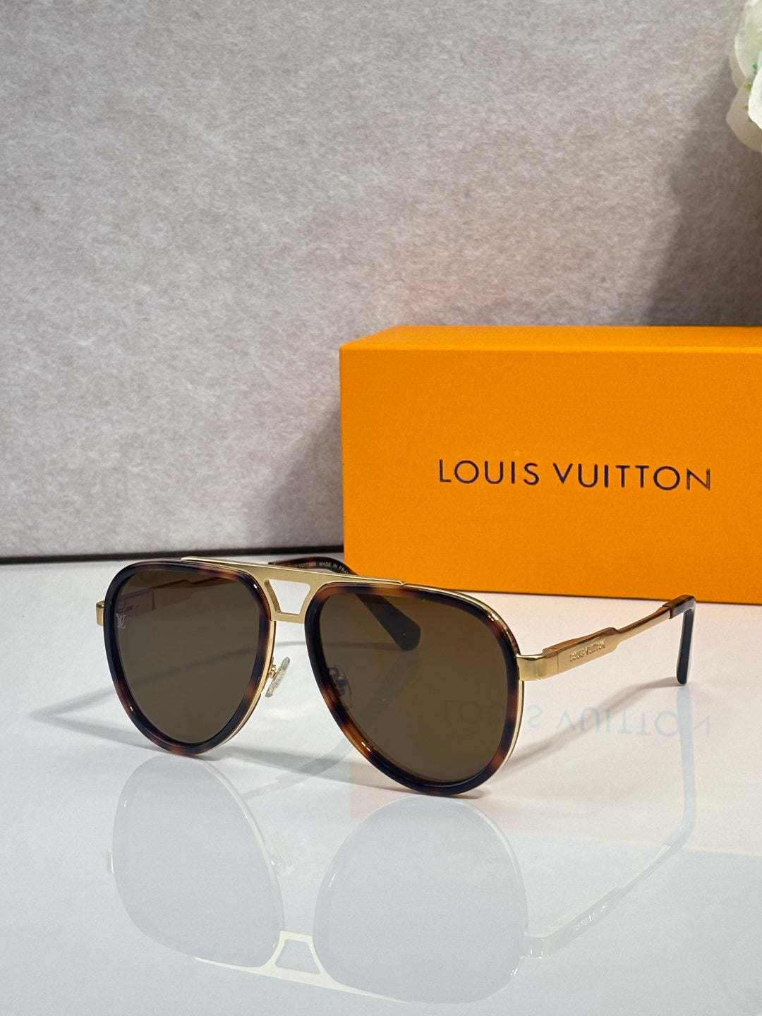 Louis Vuitton sunglasses with brown tinted lenses and gold-tone metal frame