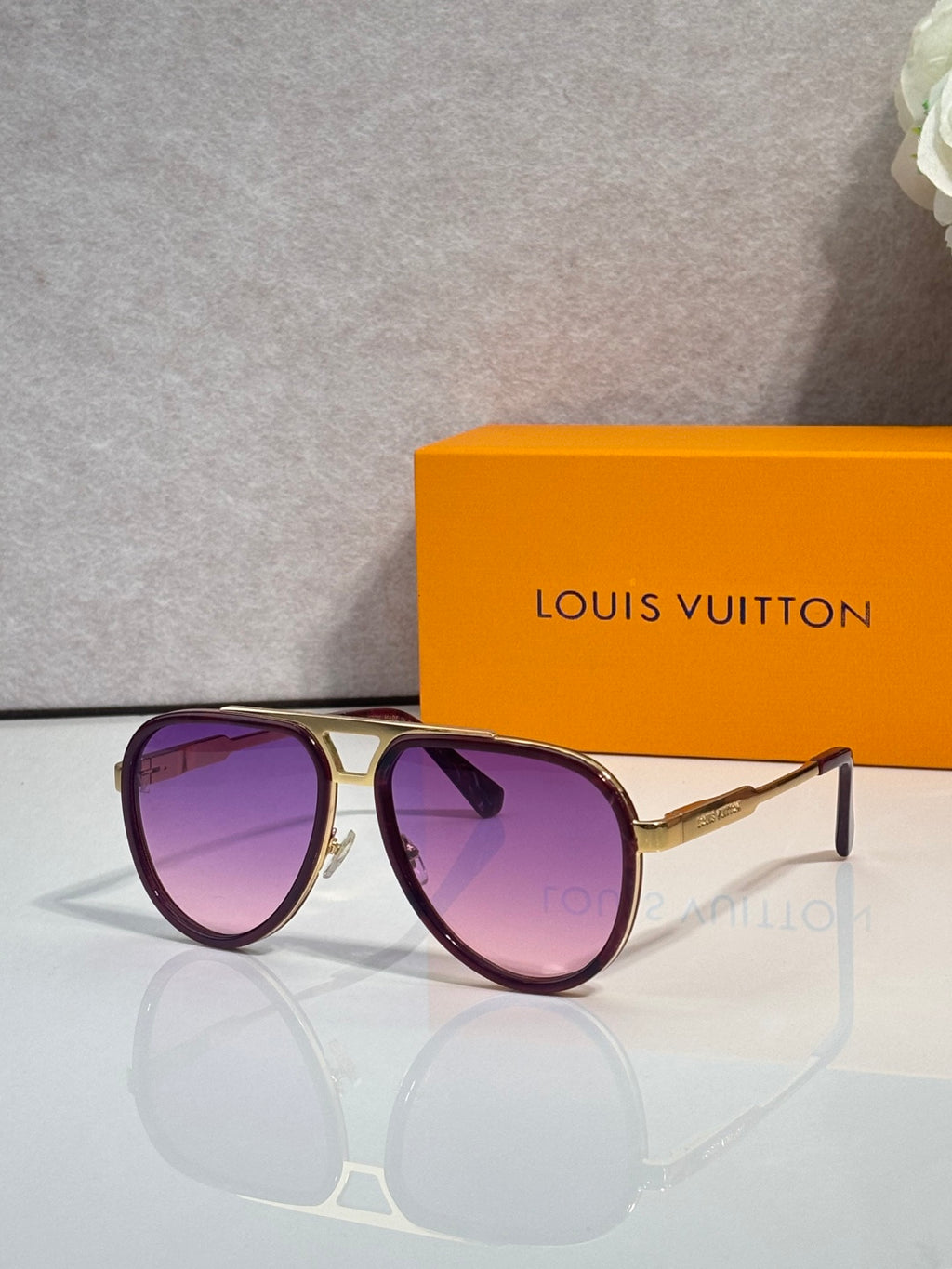 Louis Vuitton sunglasses with purple tinted lenses and gold-tone metal frame