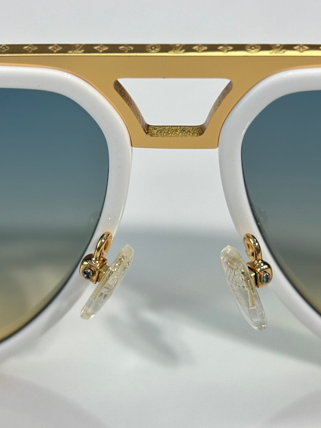 Louis Vuitton sunglasses close-up, white frame with gold-tone bridge and hinges