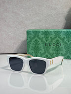 Gucci glasses with white frame and dark navy-tinted lenses, gold logo on temples