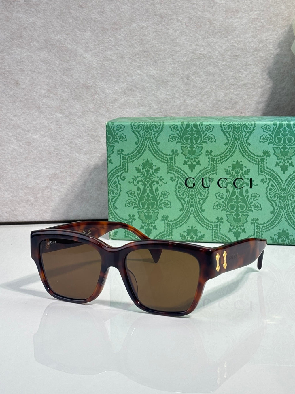 Gucci glasses with dark brown frame and brown-tinted lenses, gold side accents