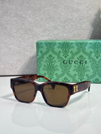 Gucci glasses with dark brown frame and brown-tinted lenses, gold side accents