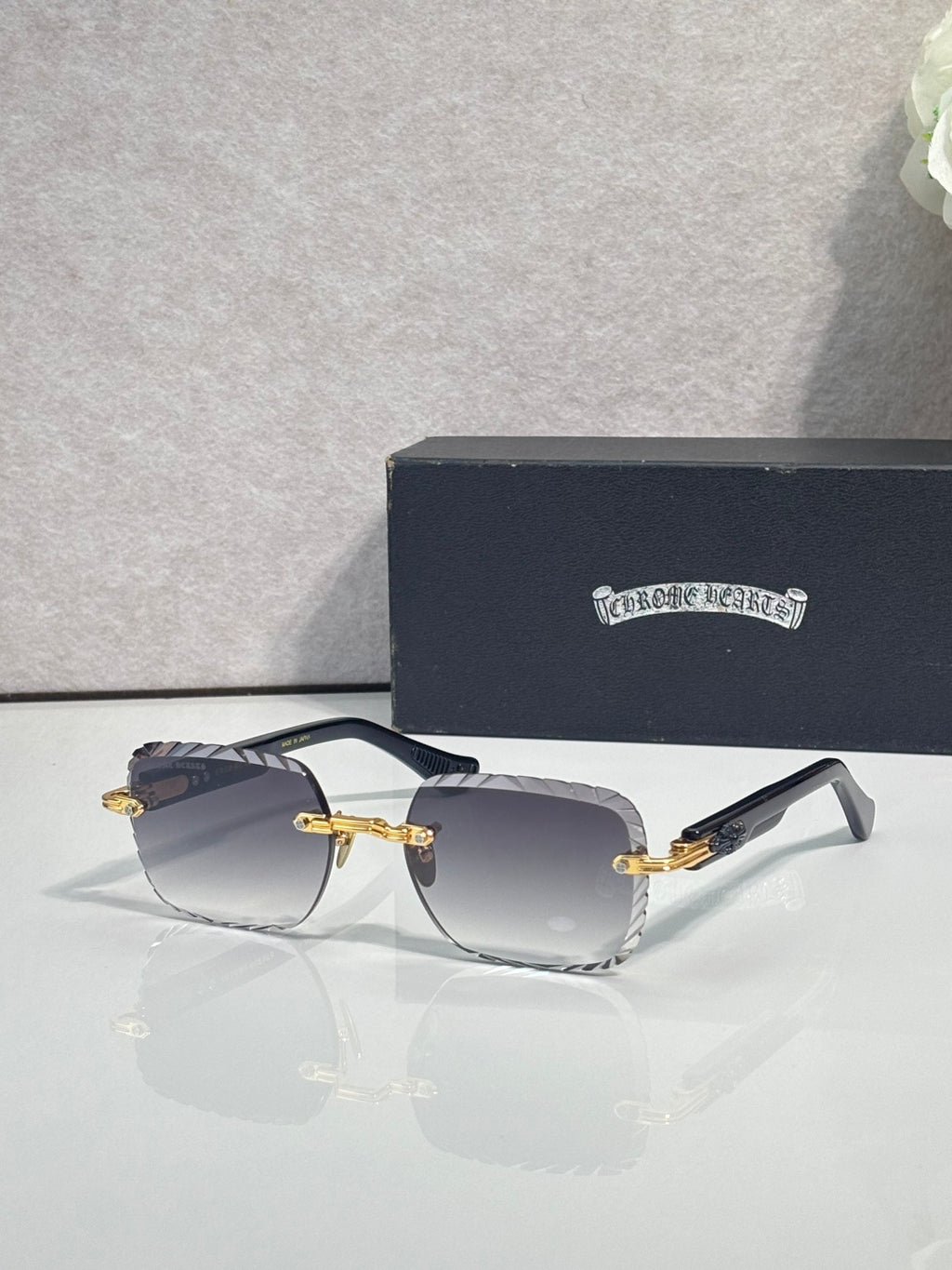 Chrome sunglasses with smoke gradient lenses, gold-tone frame, and decorative metal detail