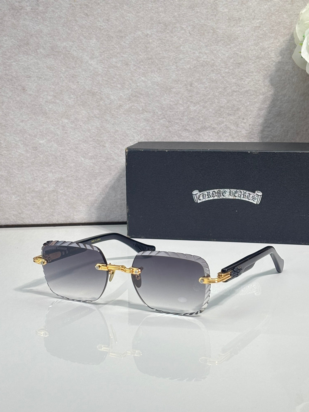 Chrome sunglasses with smoke gradient lenses, gold-tone frame, and decorative metal detail
