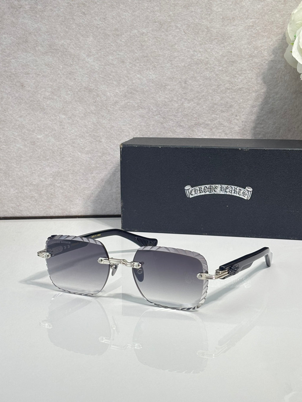 Chrome sunglasses with dark gradient lenses, black frame, and slim metal temples
