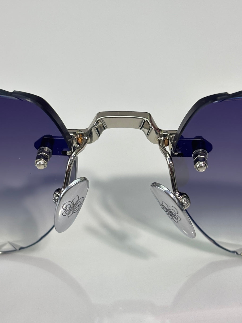 Chrome sunglasses front view with dark tinted lenses, blue temple arms, and metal hinges