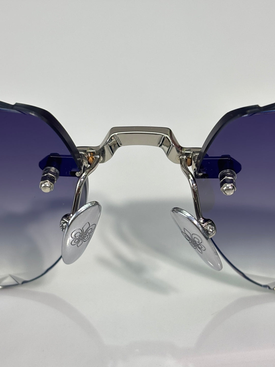 Chrome sunglasses front view with dark tinted lenses, blue temple arms, and metal hinges