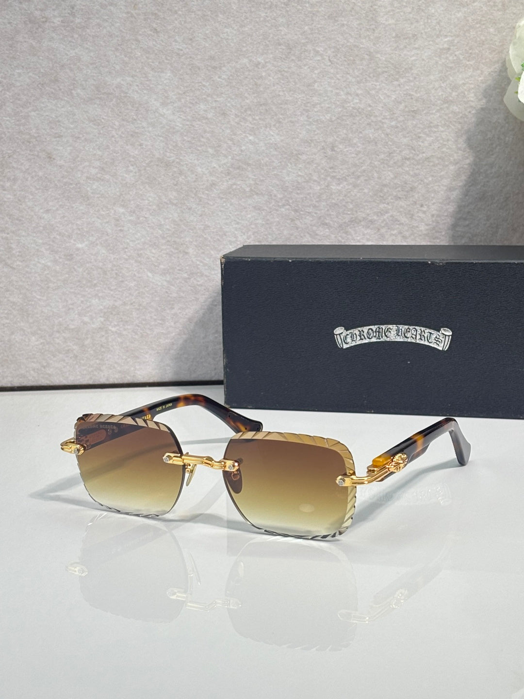 Chrome sunglasses with amber gradient lenses, gold-tone frame, and metal temple detailing